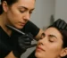 Técnica de PMU aplicada por profesional sobre cejas de una clienta en un entorno estético higiénico